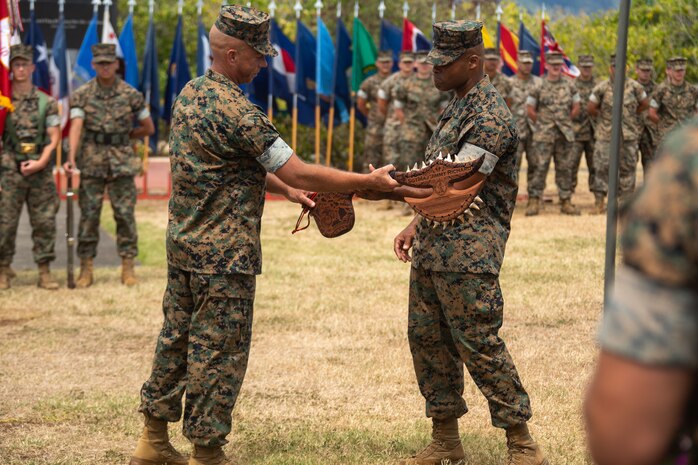 U.S. Marine Corps 1st Sgt. Kevin Hopkins, left, alpha company first sergeant, presents a plaque to U.S. Marine Corps Sgt. Maj. Jimmy Richard Jr., right, offgoing sergeant major, during the 3d radio Battalion Relief and Appointment ceremony, Marine Corps Base Hawaii, June 2, 2022. Richard was relieved as the Sergeant Major of 3rd Radio Bn. by  Sgt. Maj. Adan Moreno. (U.S. Marine Corps photo by Lance Cpl. Chandler Stacy)