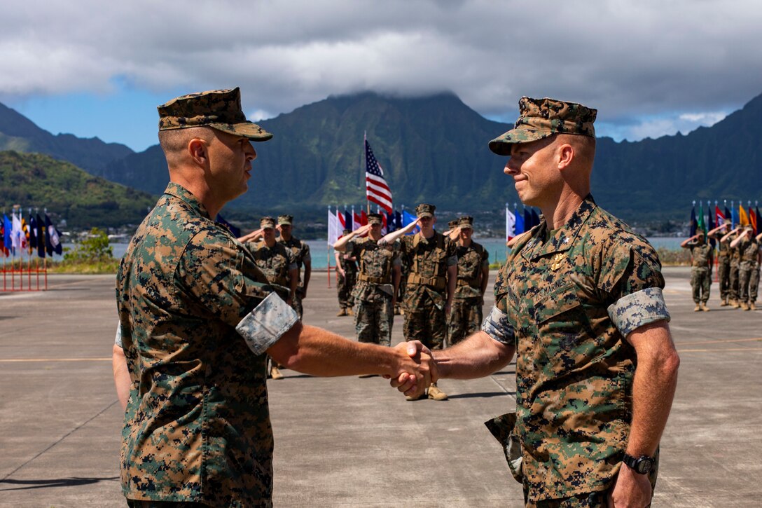 U.S. Marine Corps Lt. Col. Nicholas Law, left, incoming commanding officer, Marine Unmanned Aerial Vehicle Squadron 3, congratulates Lt. Col. Thomas Farrington, outgoing commanding officer, VMU-3, during the VMU-3 change of command ceremony, Marine Corps Air Station Kaneohe Bay, Marine Corps Base Hawaii, June 3, 2022. Farrington relinquished command to Law. (U.S. Marine Corps photo by Cpl. Samantha Sanchez)