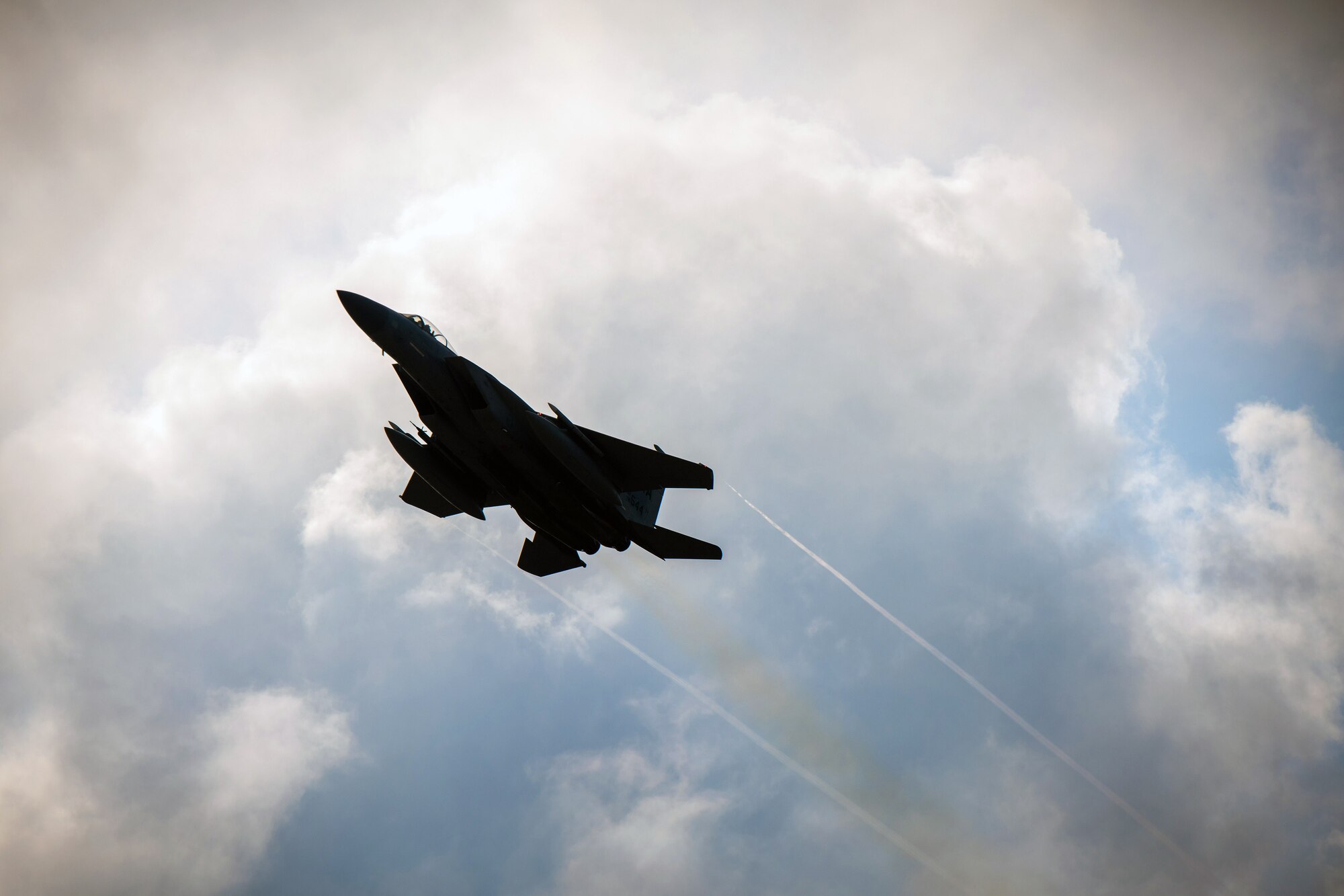 An F-15C Eagle flies over the base