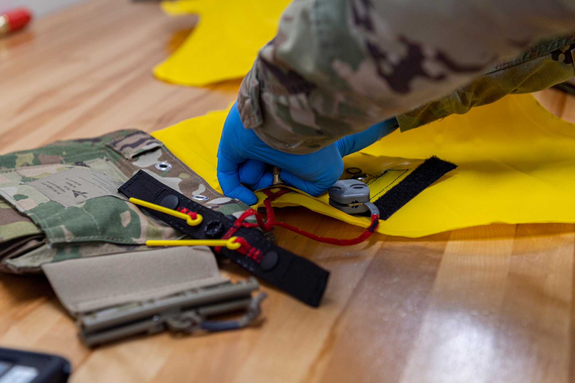 Photo of an Airman replacing rubber gaskets on a combat tactical aid flotation