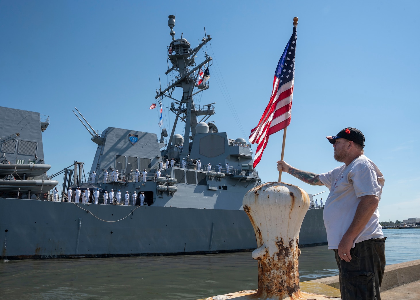 A family member of a Sailor assigned to the Arleigh Burke-class guided-missile destroyer USS Forrest Sherman (DDG 98) watches as the ship departed on deployment from its home port of Norfolk, June 11.