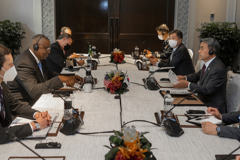 Men in suits sit at a table.