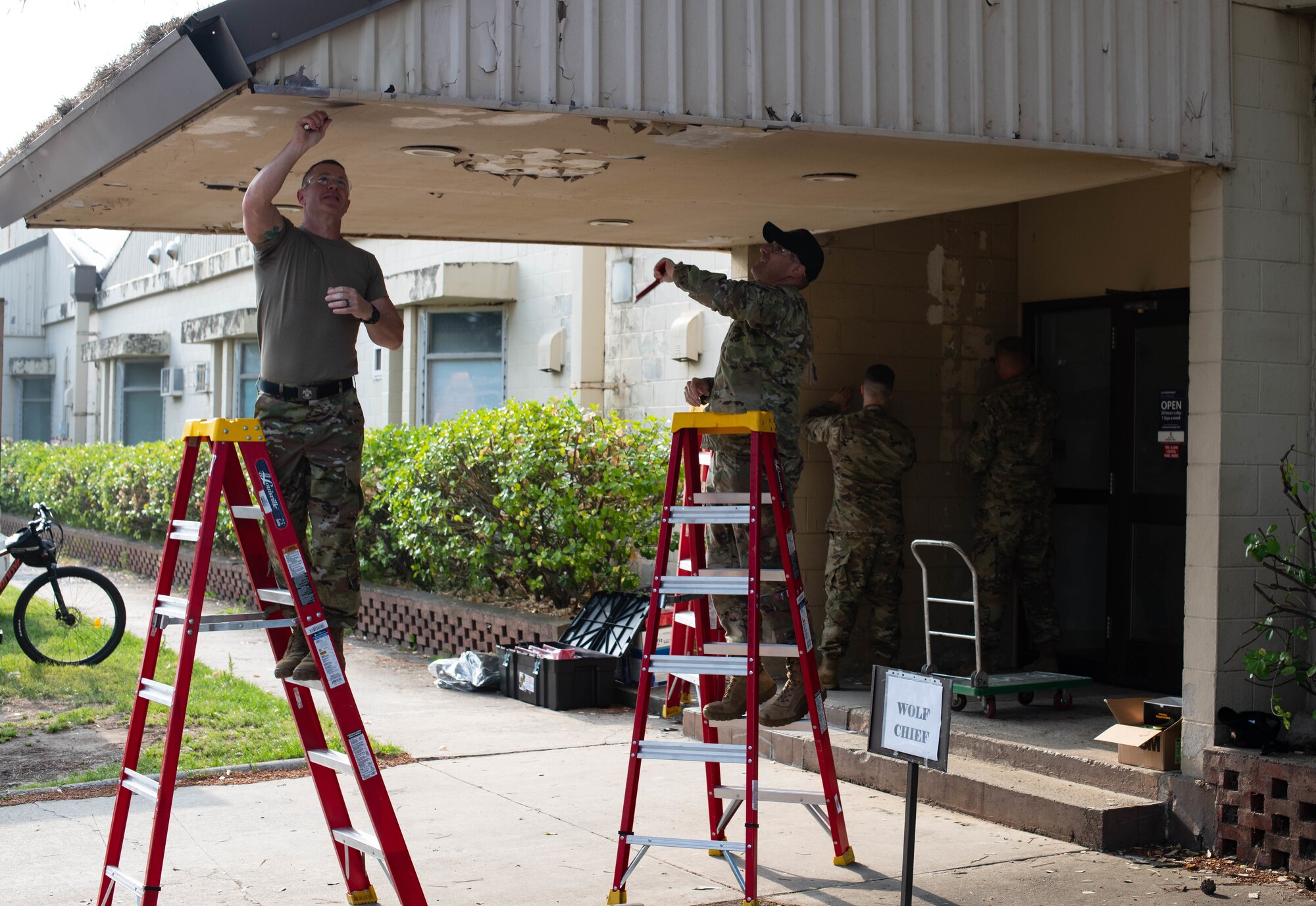 Two military men paint a roof