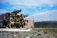 316th Civil Engineer Squadron firefighters pull a fire hose toward a simulated aircraft fire during an interagency fire-fight training at Joint Base Andrews, Md., May 2, 2022. The team trained in a live-burn exercise to practice firefighting techniques and procedures in a realistic environment, ensuring they are prepared to mitigate damage and save lives.