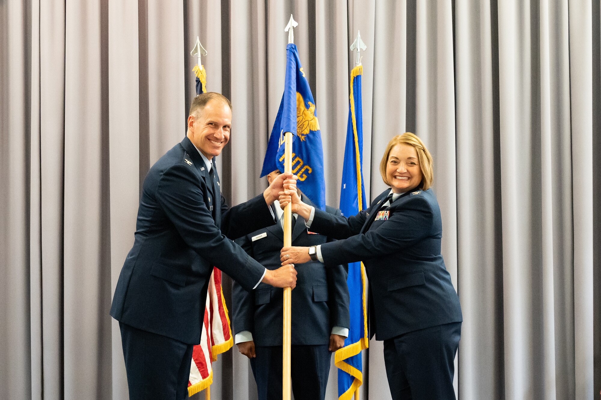 Col. Matt Husemann, left, 436th Airlift Wing commander, passes the guidon to Col. Peggy Dickson, 436th Medical Group commander, during the 436th MDG Change of Command ceremony at Dover Air Force Base, Delaware, June 9, 2022. Dickson was previously the commander of the 10th Dental Squadron at the U.S. Air Force Academy in Colorado. (U.S. Air Force photo by Mauricio Campino)