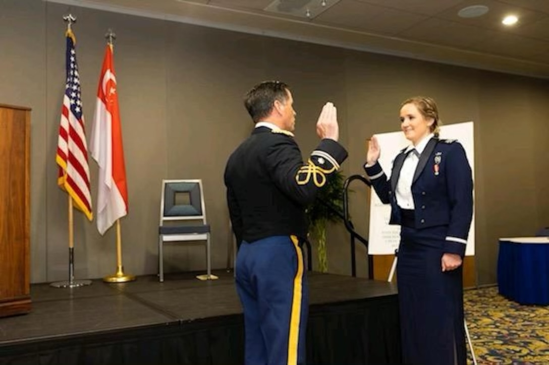 Russell Dunford, U.S. Army Engineering and Support Center, Huntsville Business Practice Division Chief, administers the oath of office to his daughter, Anne Marie, at her graduation May 25 from the Air Force Academy in Colorado Springs, Colorado. (Courtesy Photo)