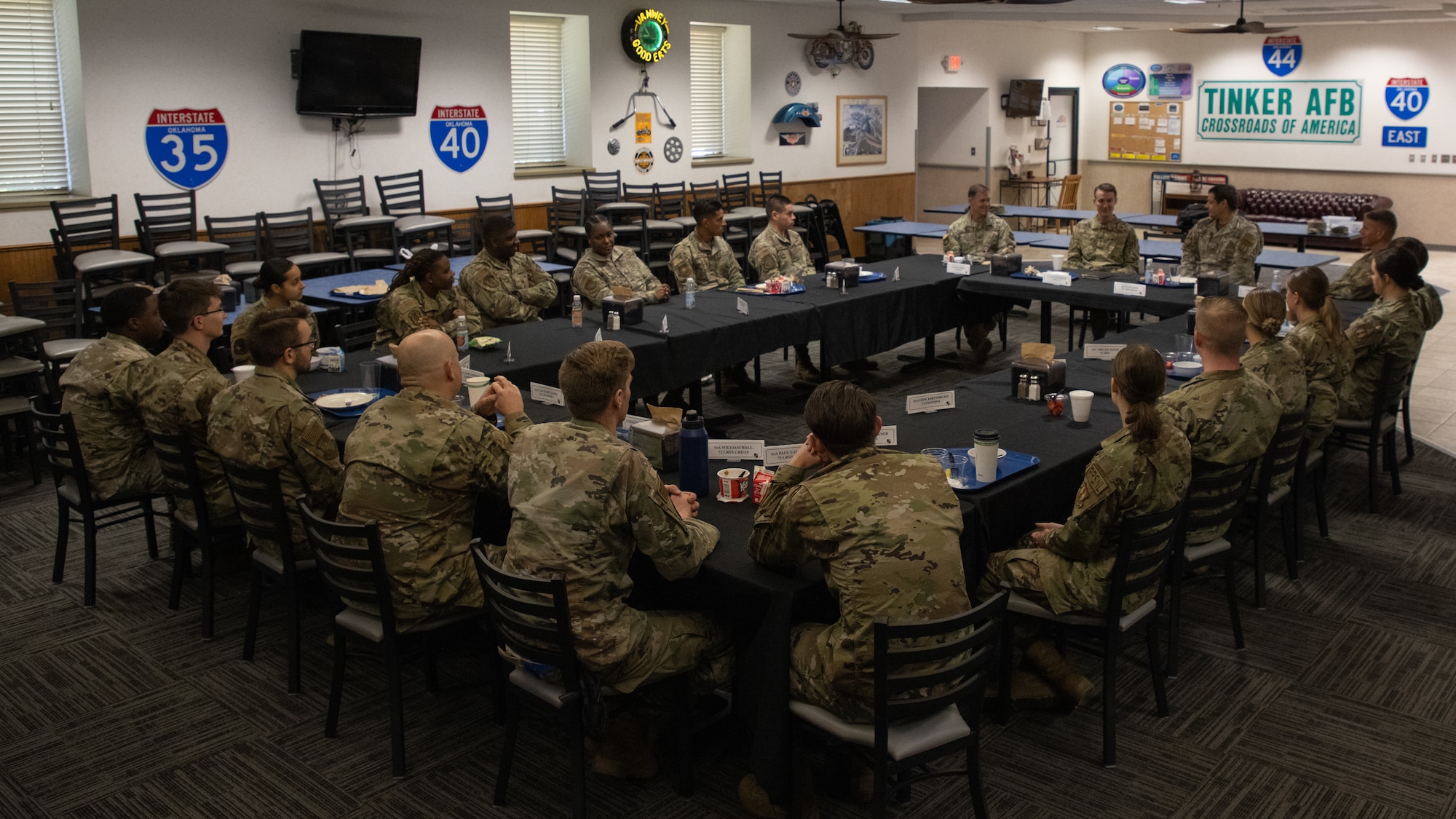 Twenty two Airmen sitting at rectangle of tables
