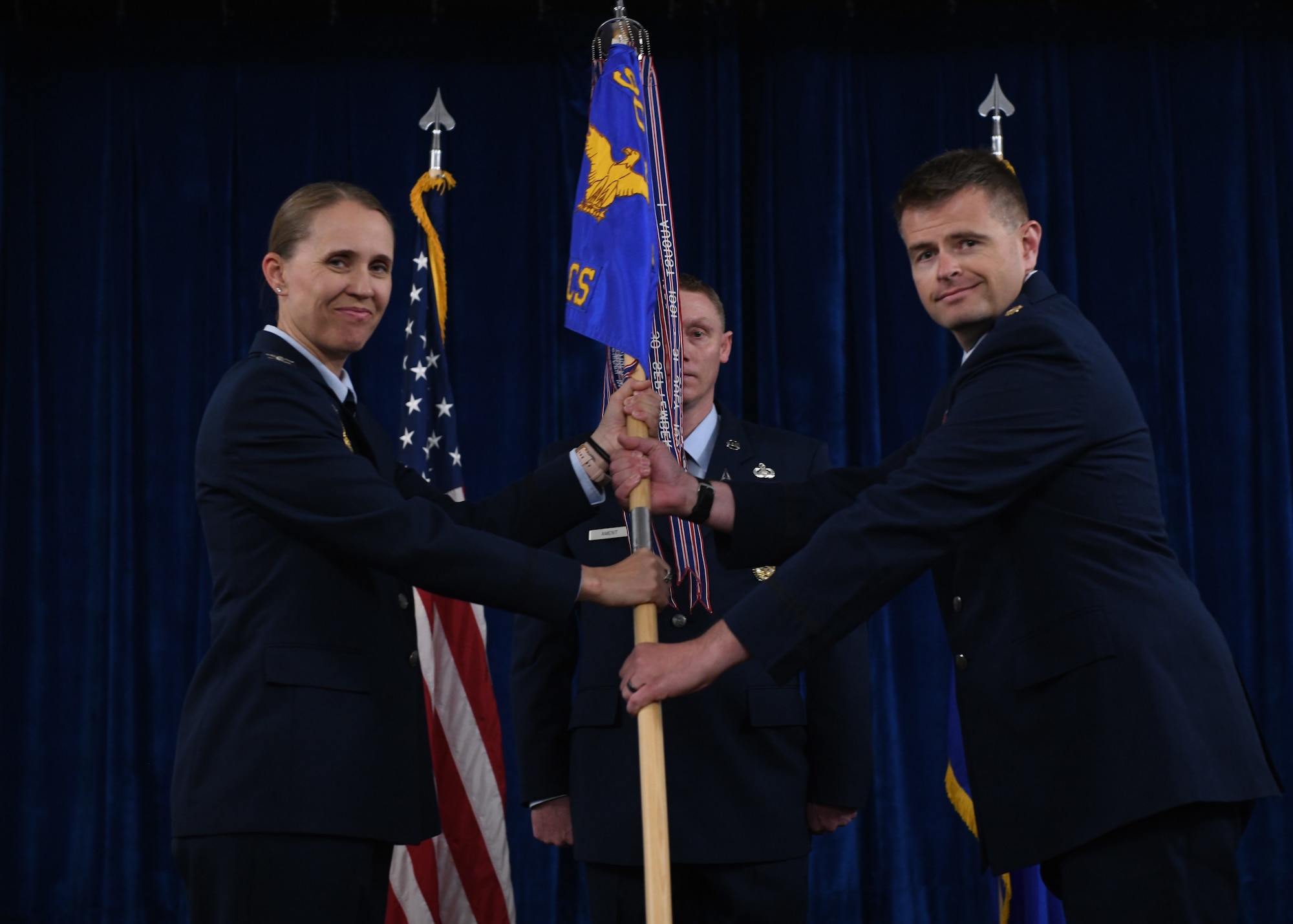 Col. Carolyn Ammons (left), commander of the 90th Mission Support Group, passes the guidon to Maj. Jeffrey Mickelsen, the incoming commander of the 90th Communication Squadron, during a change of command ceremony on F.E. Warren Air Force Base, June 13, 2022. The change of command ceremony signifies the transition of command from Lt. Col. Joseph Manning, the outgoing commander of 90 CS, to Mickelsen. (U.S. Air Force photo by Airman 1st Class Darius Frazier.)