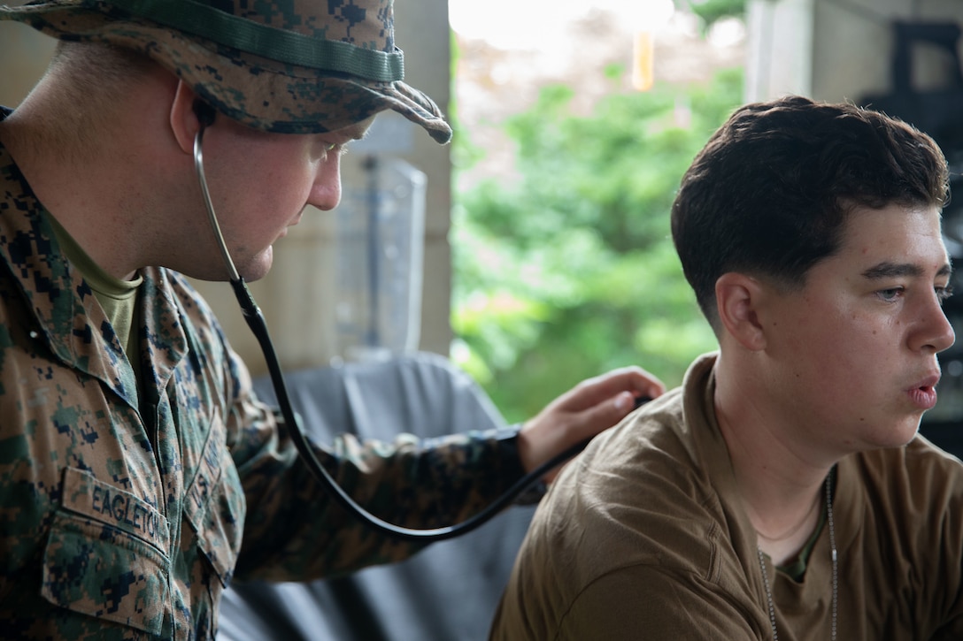 U.S. Navy Seaman John Eagleton, a corpsman with 3rd Medical Battalion, 3rd Marine Logistics Group, conducts a head-to-toe assessment during a mass casualty exercise at Combat Town, Central Training Area, Okinawa, Japan, June 9, 2022. 3rd MLG, based out of Okinawa, Japan, is a forward deployed combat unit that serves as III Marine Expeditionary Force's comprehensive logistics and combat service support backbone for operations throughout the Indo-Pacific area of responsibility.