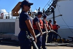 Petty Officer 2nd Class Courtney Block, a gunner’s mate, helps take in lines connecting Coast Guard Cutter Kimball (WMSL 756) to shore power as the ship gets ready to depart for final sea trials Aug. 11, 2019.