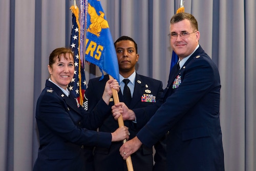 Lt. Col. John Batka, right, 436th Operational Medical Readiness Squadron commander, assumes command of the 436th OMRS after receiving the guidon from Col. Tracy Allen, left, 436th Medical Group commander, during a change of command ceremony held at The Landings on Dover Air Force Base, Delaware, June 9, 2022. The 436th OMRS Change of Command was the third of four ceremonies conducted within the 436th MDG. Guidon bearer for the ceremony was Master Sgt. Andrew Burgos, center, 436th OMRS superintendent. (U.S. Air Force photo by Roland Balik)