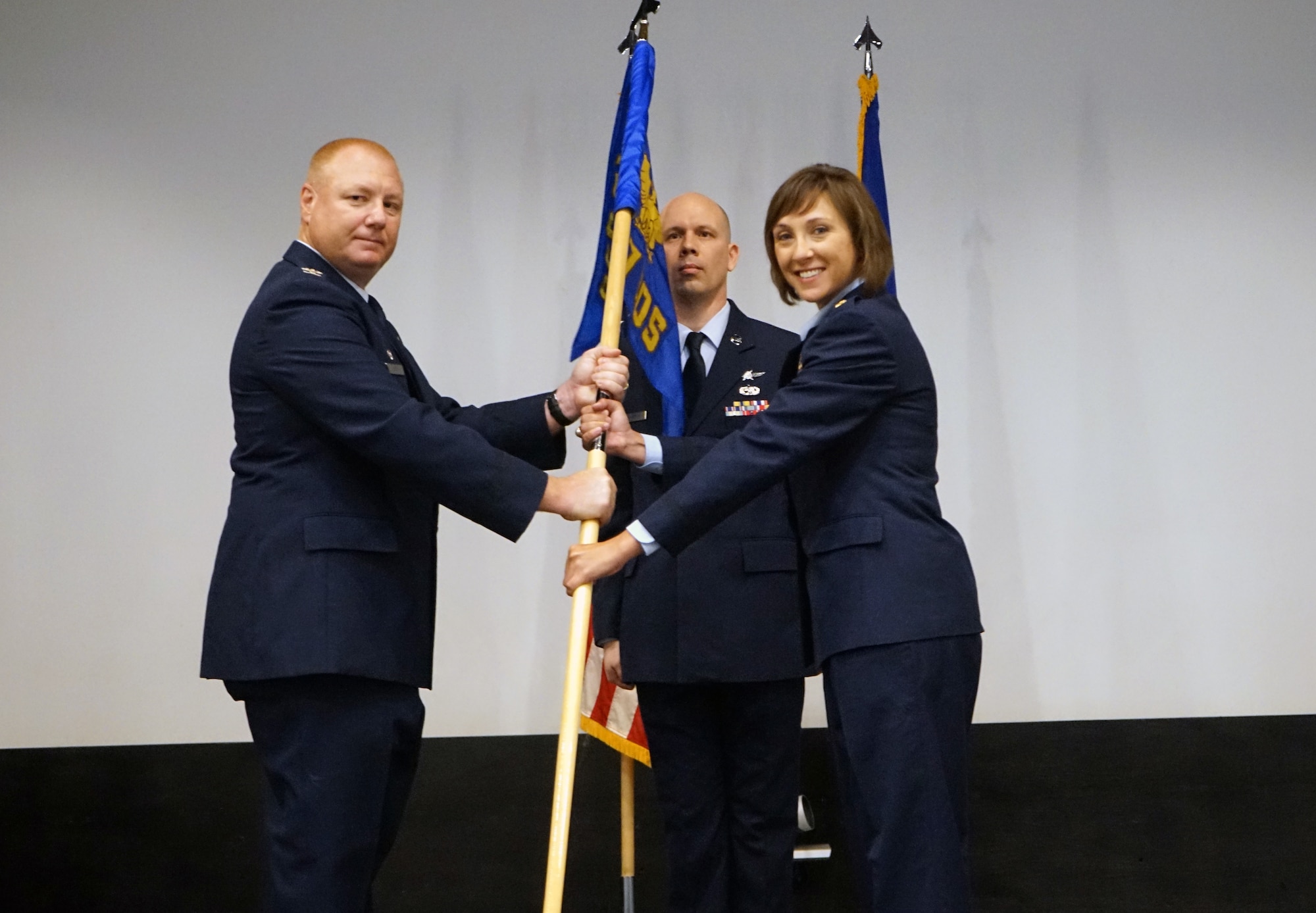 Col. Thaddeus Janicki Jr., 860th Cyberspace Operations Group commander, hands a guidon to Maj. Megan Kell, signifying her assumption of command of the 717th Information Operations Squadron during a ceremony May 15, 2022, at Hurlburt Field, Florida.