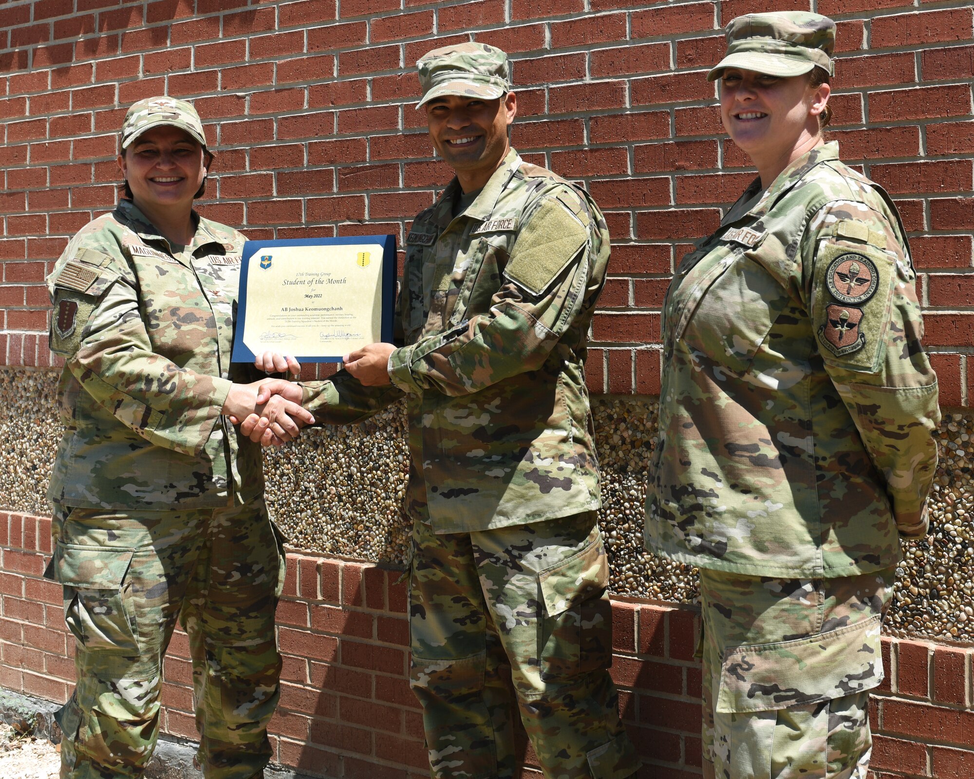 U.S. Air Force Col. Angelina Maguinness, 17th Training Group commander, and Senior Master Sgt. Heather Celano, 313th Training Squadron senior enlisted leader, presents the 312th Training Squadron Enlisted Student of the Month award to Airman Joshua Keomuongchanh, 312th TRS student, Goodfellow Air Force Base, Texas, June 10, 2022. Keomuongchanh worked hard for his award and has shown his dedication to his squadron and the training he received at Goodfellow. (U.S. Air Force photo by Airman 1st Class Zachary Heimbuch)