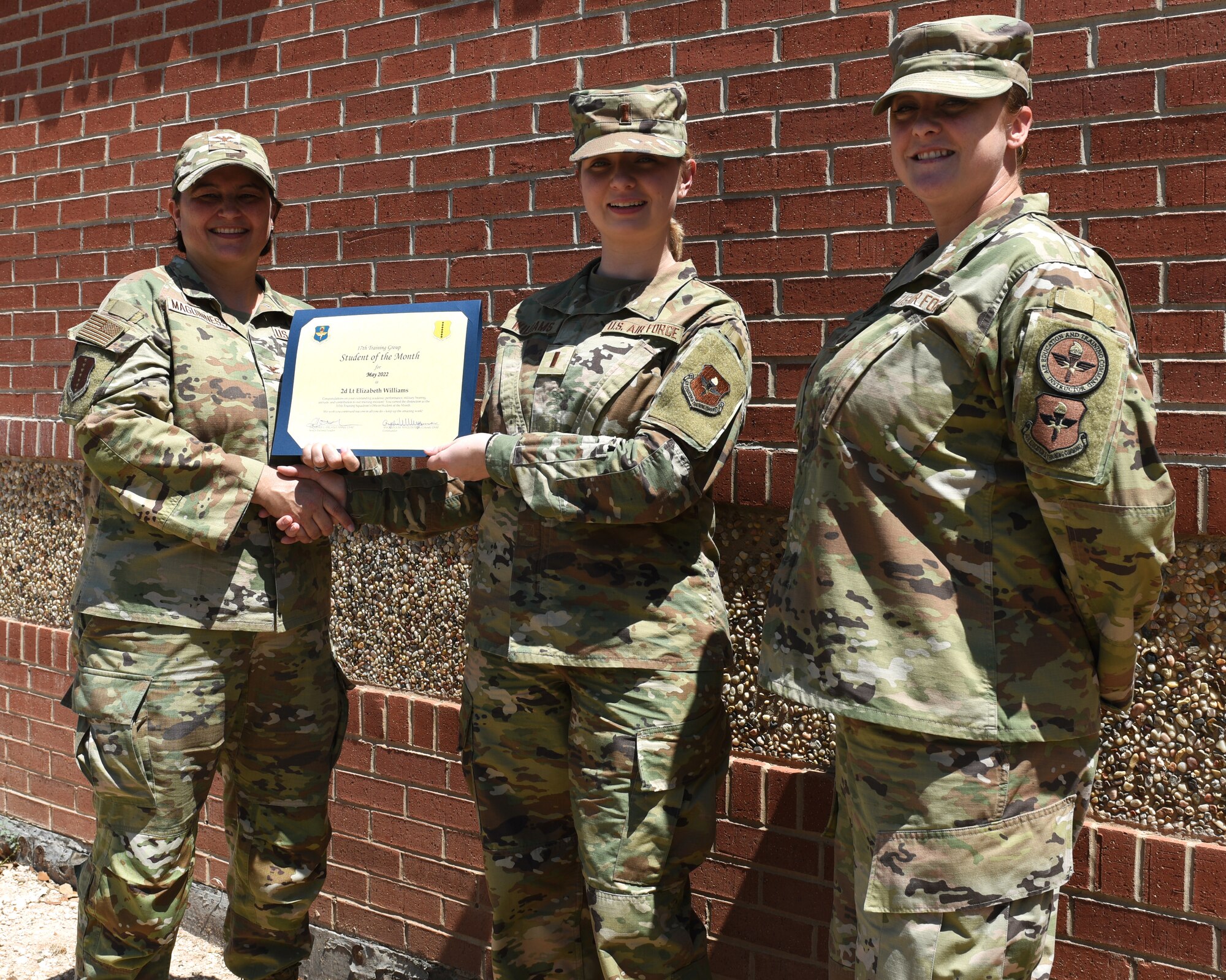 U.S. Air Force Col. Angelina Maguinness, 17th Training Group commander, and Senior Master Sgt. Heather Celano, 313th Training Squadron senior enlisted leader, presents the 315th Training Squadron Officer Student of the Month award to 2nd Lt. Elizabeth Williams, 315th TRS student, Goodfellow Air Force Base, Texas, June 10, 2022. Williams worked hard for her award and has shown her dedication to her squadron and the training she received at Goodfellow. (U.S. Air Force photo by Airman 1st Class Zachary Heimbuch)