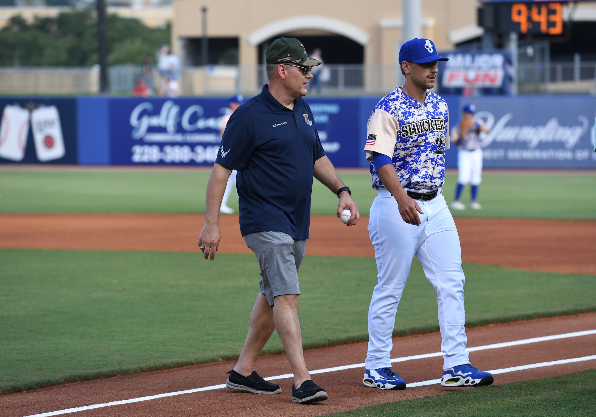 U.S. Air Force Col. James Kafer, 81st Training Wing vice commander, and a Biloxi Shuckers team member, walk off the field following a ceremonial first pitch thrown by Kafer during the Biloxi Shuckers Minor League Baseball game in Biloxi, Mississippi, June 11, 2022. The Shuckers hosted a military appreciation night where service members received free tickets. (U.S. Air Force photo by Kemberly Groue)