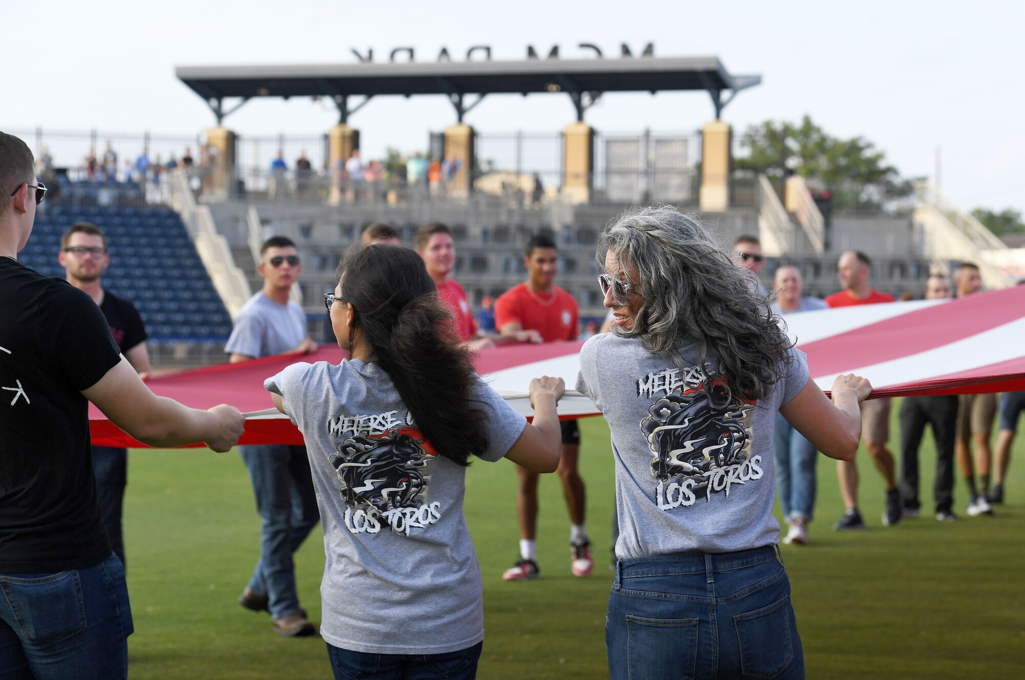 Airmen from the 81st Training Group hold a U.S. flag during the Biloxi Shuckers Minor League Baseball game in Biloxi, Mississippi, June 11, 2022. The Shuckers hosted a military appreciation night where service members received free tickets. (U.S. Air Force photo by Kemberly Groue)