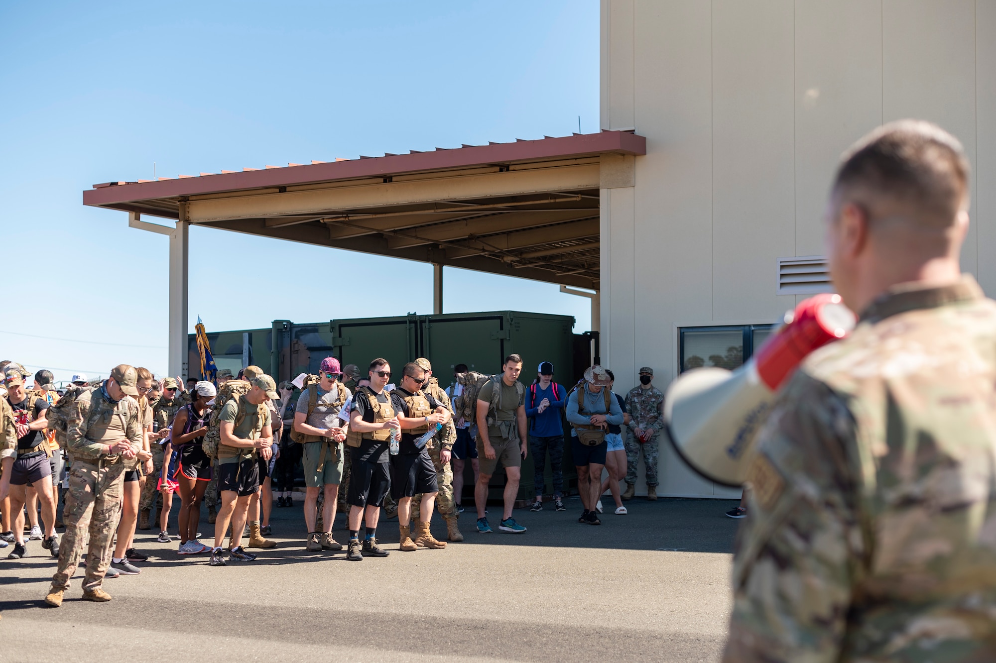 An Airman uses a megaphone to talk to other Airmen.