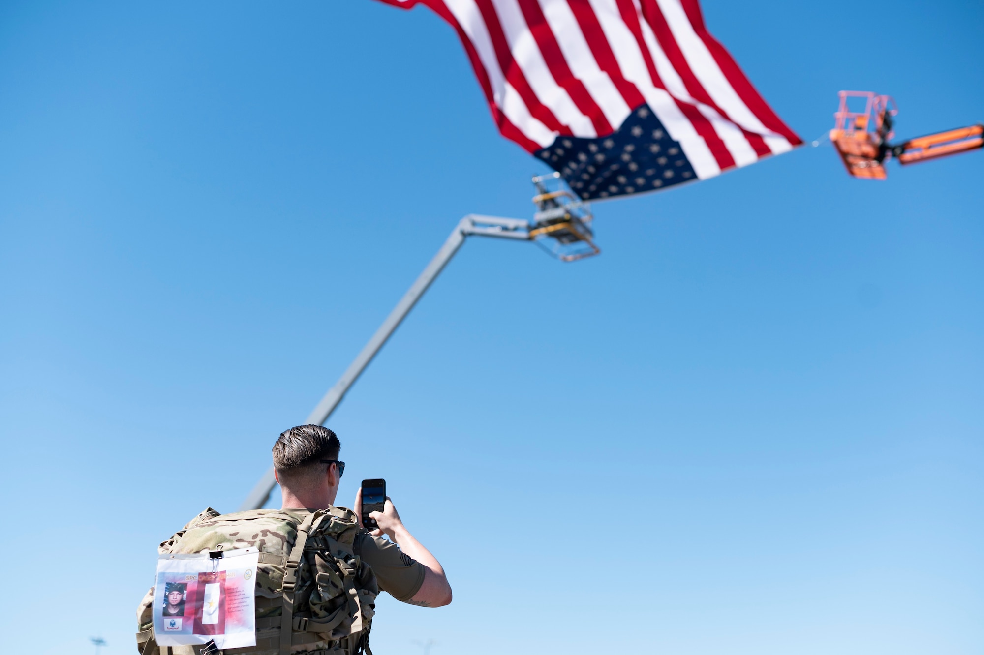 An Airman takes a photo on a phone.