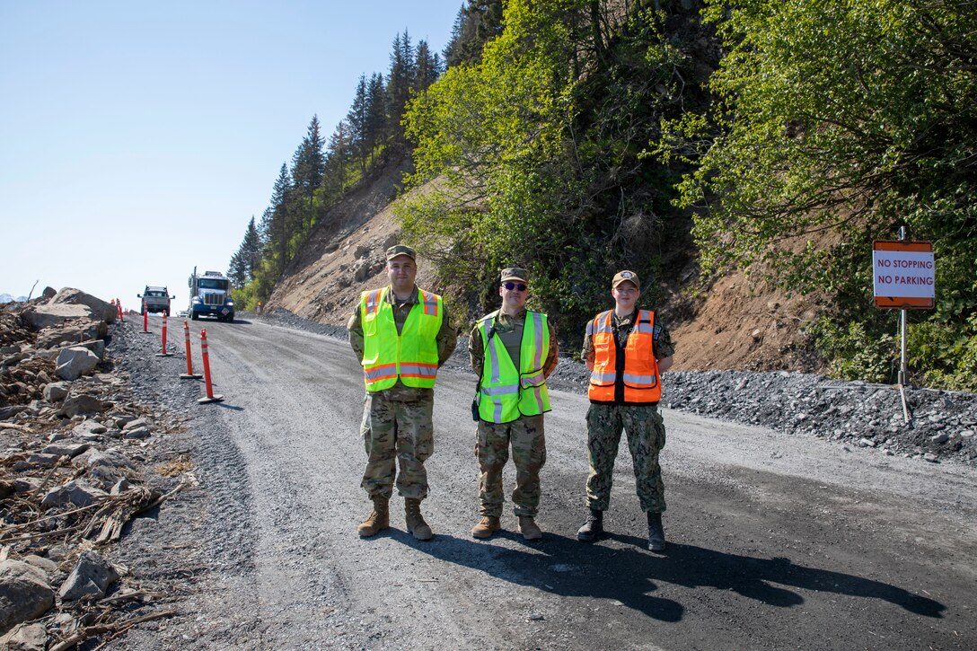 From the left, Pvt. Michael Mondrell and Pfc. Mulcahy-Hill, both with the Alaska State Defense Force, and Intelligence Specialist Seaman Katrina Clayton, Alaska Naval Militia, prepare to provide traffic control during a temporary Lowell Point Road opening on May 27, 2022 in Seward. The May 7 Bear Mountain landslide blocked the road and access to and from the community of Lowell Point for 20 days. An Alaska Organized Militia Task Force was activated following a request from the State Emergency Operations Center for support to aide with traffic controls and other duties assigned by the incident commander. (Alaska National Guard photo by 1st Lt. Balinda O’Neal)