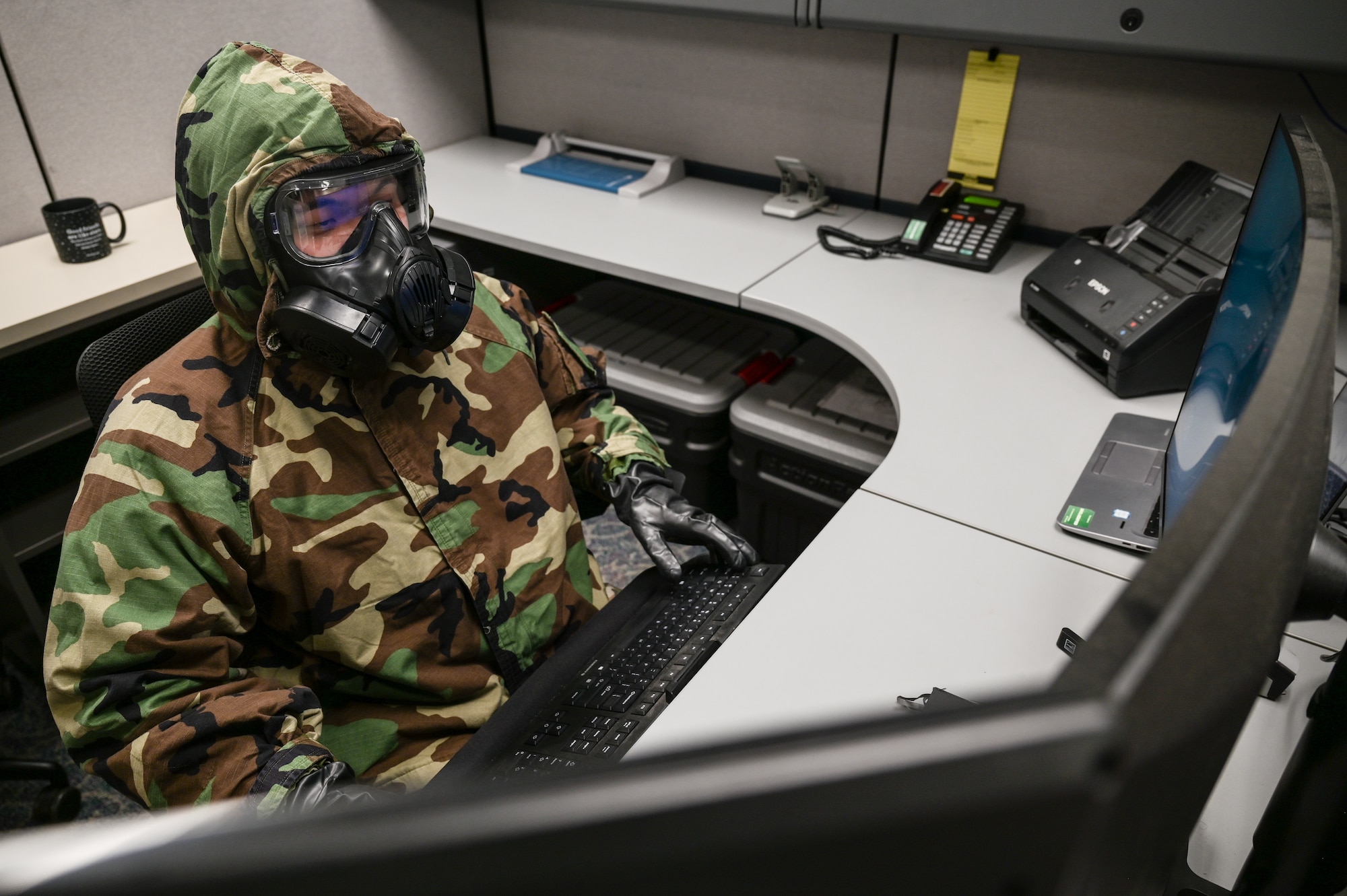 Tech. Sgt. Kevin Wu, 15th Maintenance Group maintenance qualification training program instructor, performs administration duties on a computer in mission-oriented protective posture gear at Joint Base Pearl Harbor-Hickam, Hawaii, May 24, 2022. The 15th MXG is implementing its Agile Combat Employment and chemical, biological, radiological, nuclear and high-yield explosive task qualification training plans in order to increase their readiness and versatility. (U.S. Air Force photo by Staff Sgt. Alan Ricker)