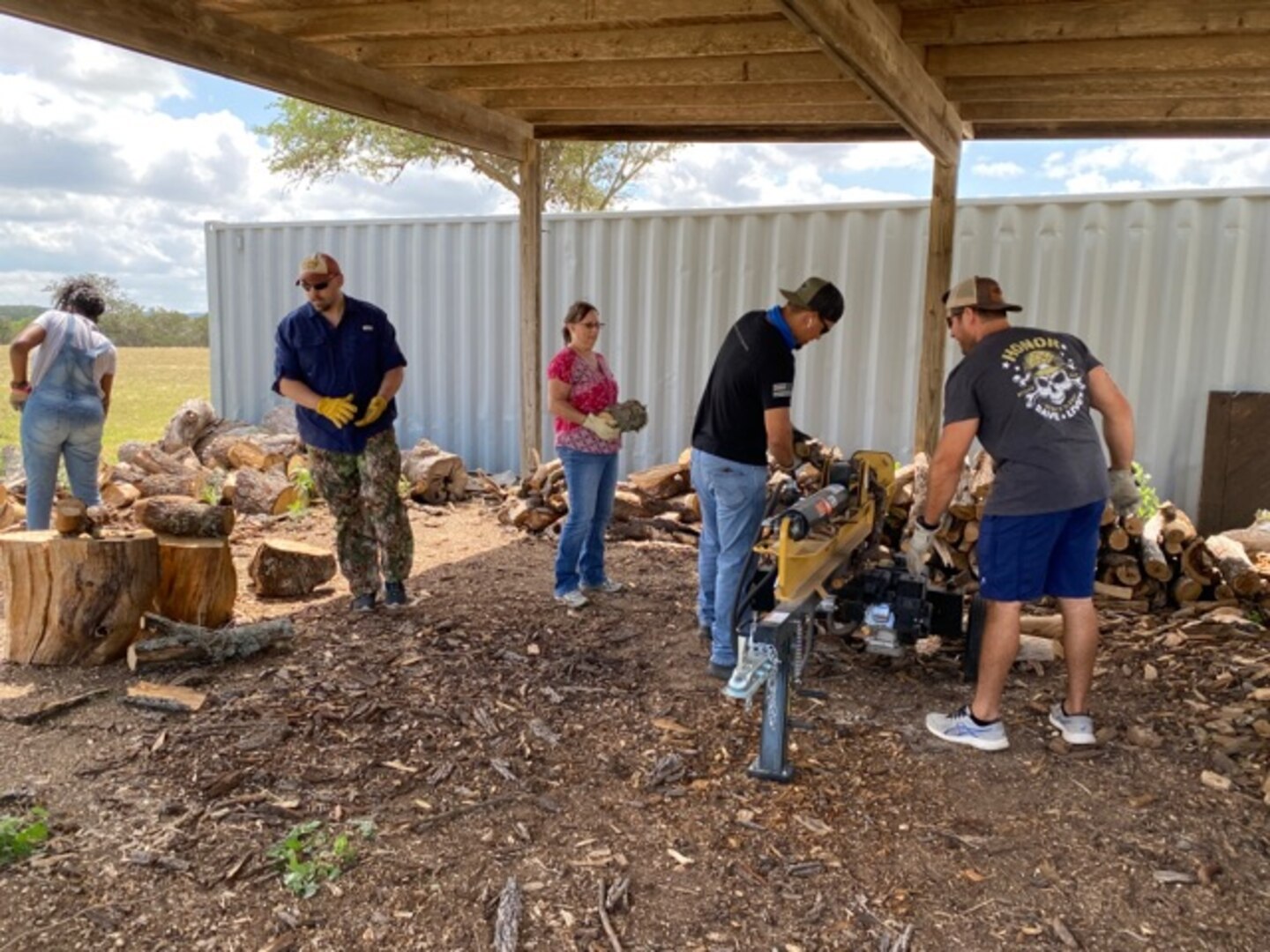 960th Cyberspace Wing Reserve Citizen Airmen chop and stack firewood May 31, 2022, at the Warriors Heart Treatment Center in Bandera, Texas.