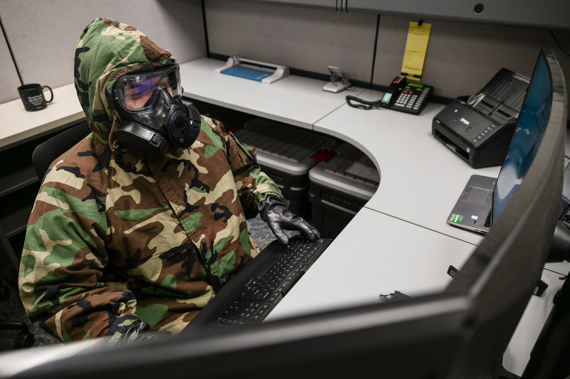 Tech. Sgt. Kevin Wu, 15th Maintenance Group maintenance qualification training program instructor, performs administration duties on a computer in mission-oriented protective posture gear at Joint Base Pearl Harbor-Hickam, Hawaii, May 24, 2022. The 15th MXG is implementing its Agile Combat Employment and chemical, biological, radiological, nuclear and high-yield explosive task qualification training plans in order to increase their readiness and versatility. (U.S. Air Force photo by Staff Sgt. Alan Ricker)