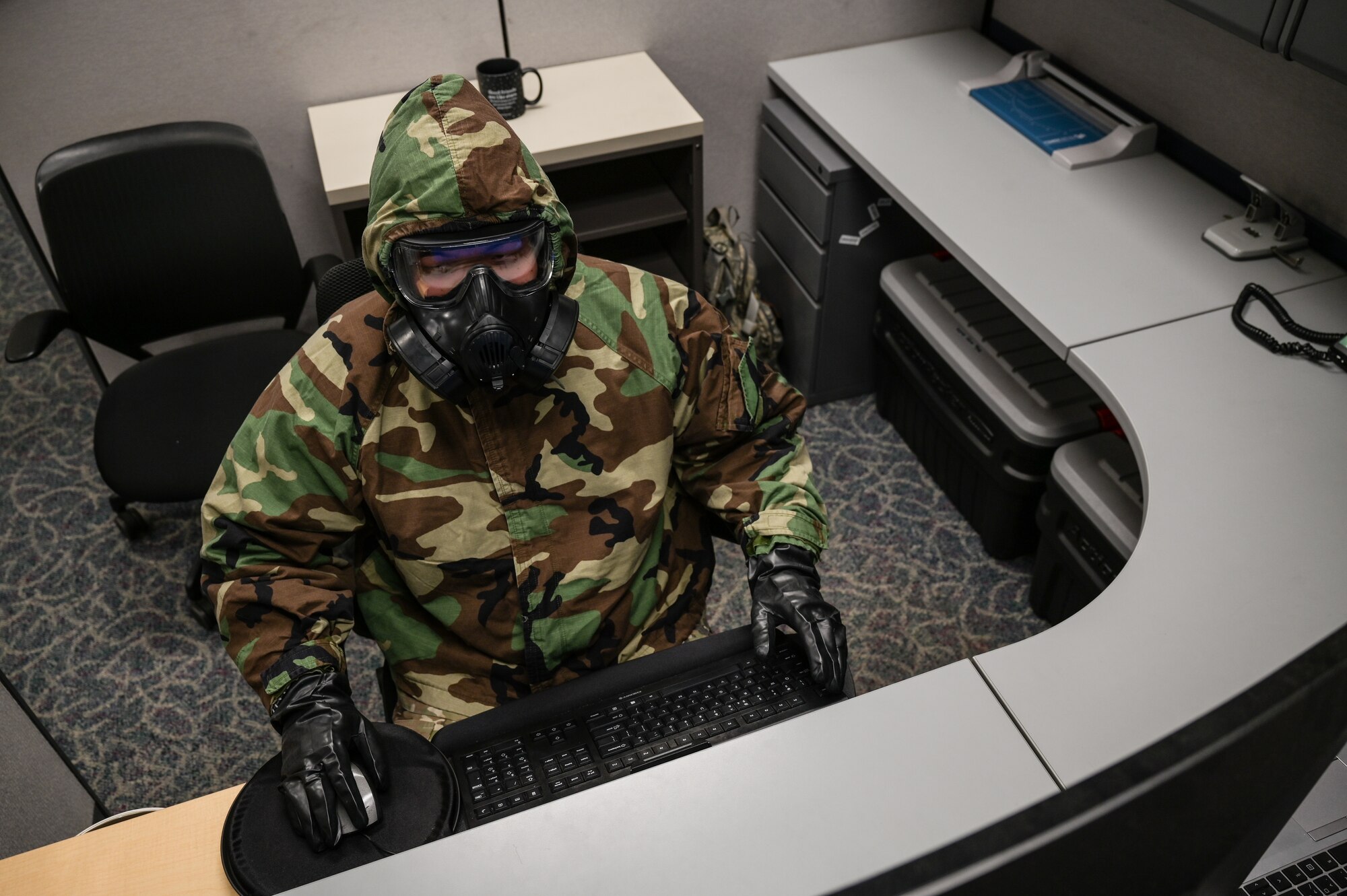 Tech. Sgt. Kevin Wu, 15th Maintenance Group maintenance qualification training program instructor, performs administration duties on a computer in mission-oriented protective posture gear at Joint Base Pearl Harbor-Hickam, Hawaii, May 24, 2022. The 15 Maintenance Group plans to have 75% of the 15th Aircraft Maintenance Squadron C-17 Globemaster III Aircraft Maintenance Unit qualified for Agile Combat Employment. (U.S. Air Force photo by Staff Sgt. Alan Ricker)