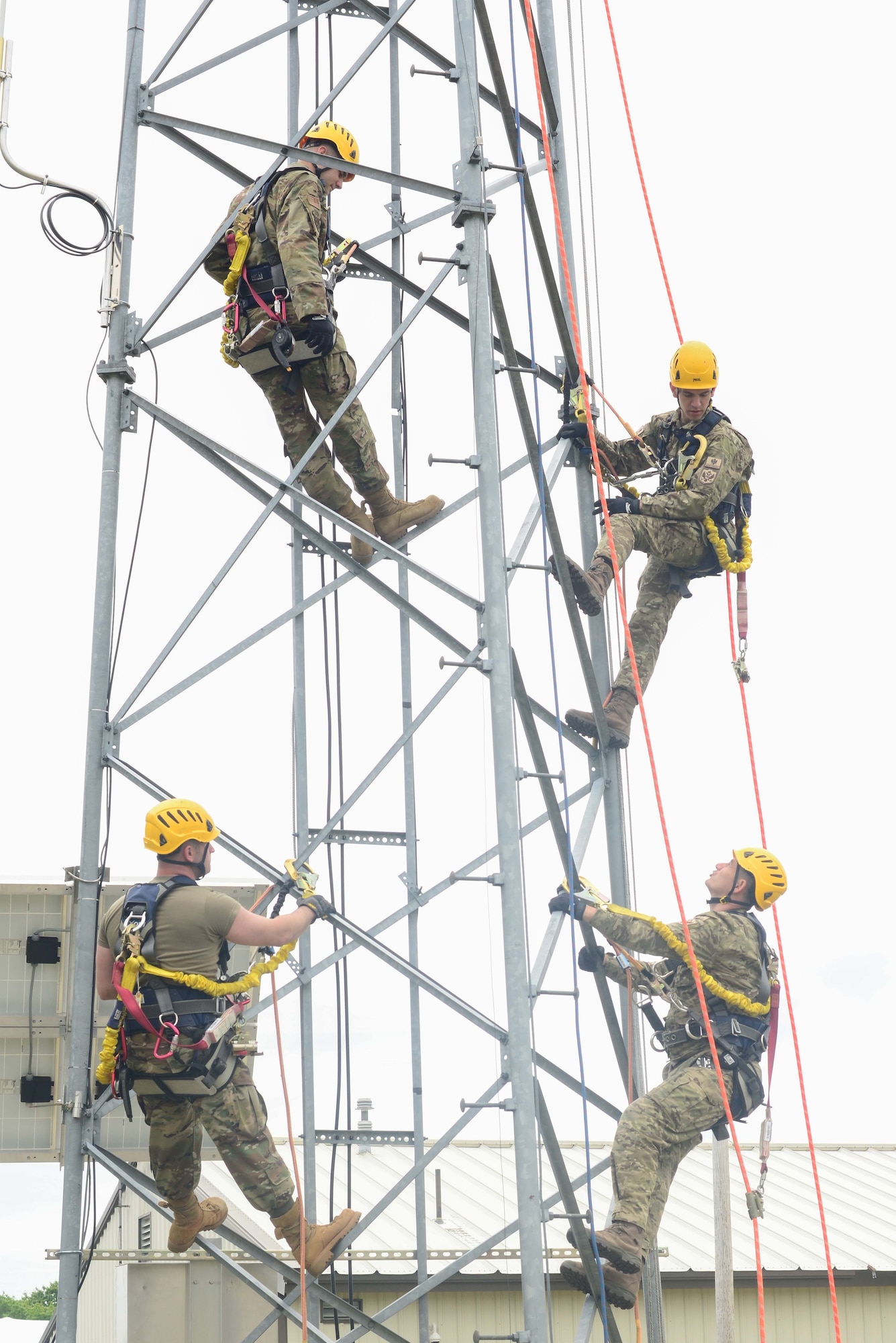 Officers from the Montenegrin army and members of the Maine Air National Guard climb a communications tower at the South Portland Air National Guard Station June 1, 2022. Four officers from Montenegro participated in communications familiarization events with the 243rd Engineering Installations Squadron and 265th Combat Communications Squadron during a State Partnership Program visit.