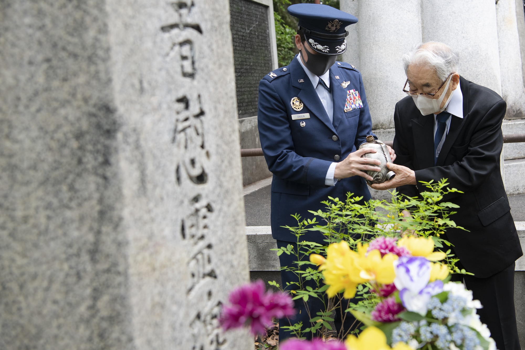 U.S. Air Force Col. Julie Gaulin, 374th Airlift Wing vice commander, left, and Dr. Hiroya Sugano, right, ceremony host, prepare to pour bourbon over a B-29 Monument as a tradition to honor the fallen during a U.S.-Japan Joint Memorial Service June 11, 2022, at Mt. Shizuhata in Shizuoka city, Japan. The memorial service provided participants the opportunity to honor those who lost their lives during a World War II air raid on June 20, 1945. During the raid, two U.S. Army Air Forces B-29 Superfortresses collided mid-air over Shizuoka City, resulting in the death of 23 Airmen on board the aircraft. Representatives of the U.S. Air Force’s Yokota Air Base, Japan Self Defense Force, and Shizuoka City rendered their respects to the Airmen and Japanese civilians who lost their lives as a result of the tragedy, and reflected on the strong alliance the U.S. and Japan have forged since the end of World War II. (U.S. Air Force photo by Tech. Sgt. Christopher Hubenthal)