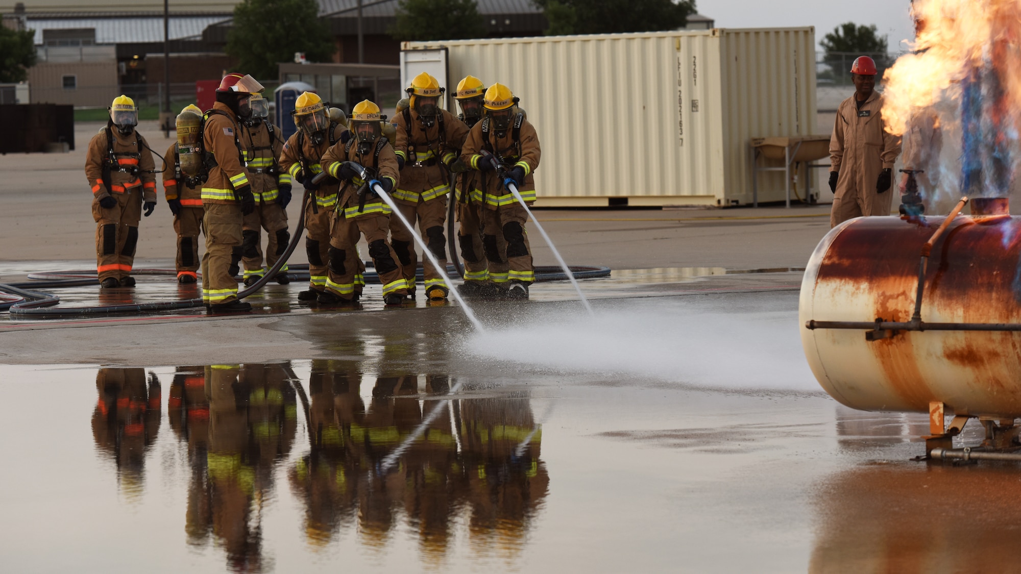 Joint service members assigned to the 312th Training Squadron prepare to advance towards a gas cylinder fire during a training assessment, at Goodfellow Air Force Base, Texas, June 9, 2022. Students train in a joint environment to enhance interoperability amongst service members. (U.S. Air Force photo by Airman 1st Class Zachary Heimbuch)