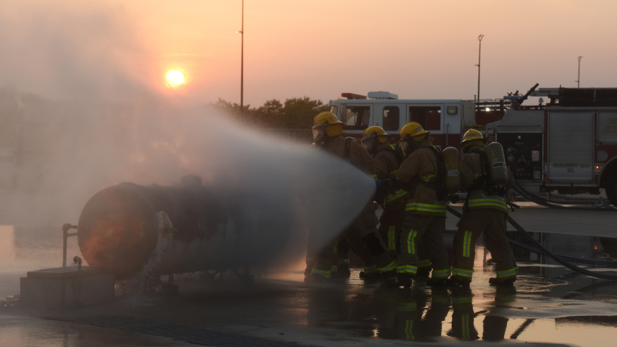 Students assigned to the 312th Training Squadron extinguish a gas cylinder fire during a training assessment, at Goodfellow Air Force Base, Texas, June 9, 2022. After the team reaches the cylinder, the crew chief closes the relief valve of the cylinder to prevent the fire from entering or more fuel exiting the container. (U.S. Air Force photo by Airman 1st Class Zachary Heimbuch)