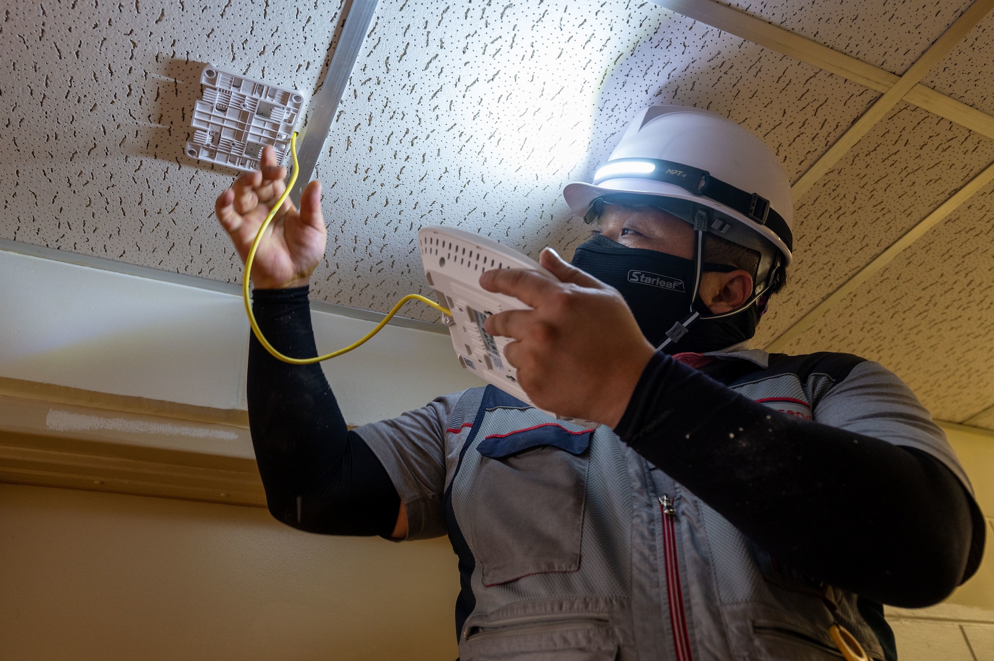 Cho Mansu, Korean Telecom engineer, installs an access point as part of the base Wi-Fi project inside a building at Kunsan Air Base, Republic of Korea, June 9. 2022. The base Wi-Fi project is a culmination of efforts for Kunsan Airmen, the U.S. Army Contracting Support Brigade and Korea Telecom. (U.S. Air Force Photo by Senior Airman Akeem K. Campbell)