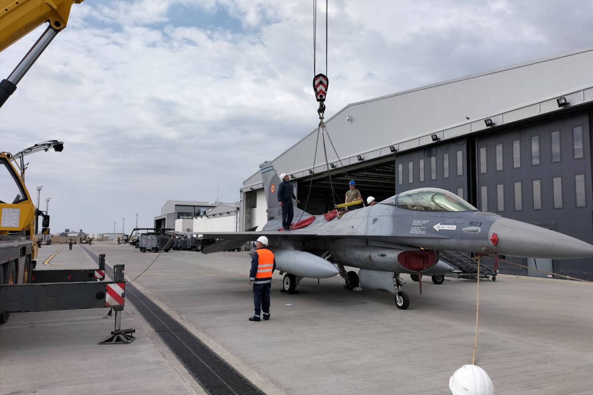 U.S. Airmen from the 31st Maintenance Group train with Romanian air force maintainers to prepare an F-16 Fighting Falcon for a crane lift