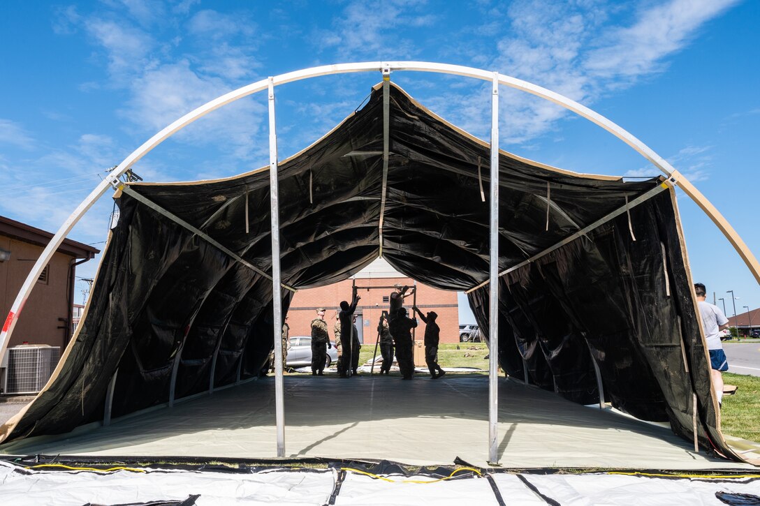 Airmen set up a large tent.