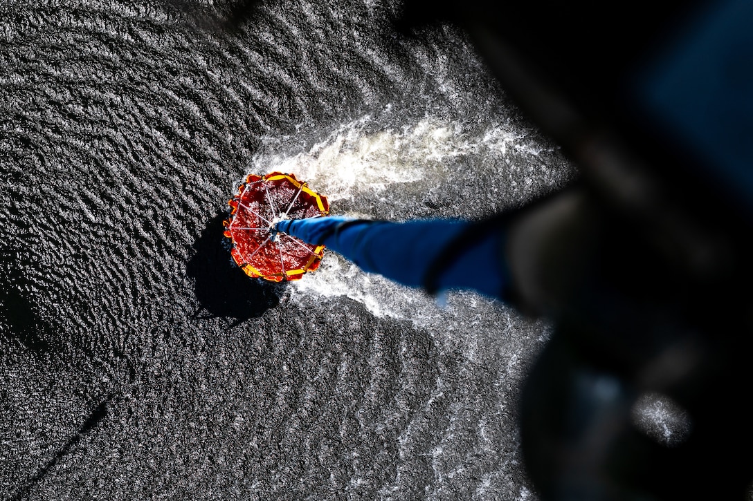 A bucket attached to a rope is seen from above gliding across water.