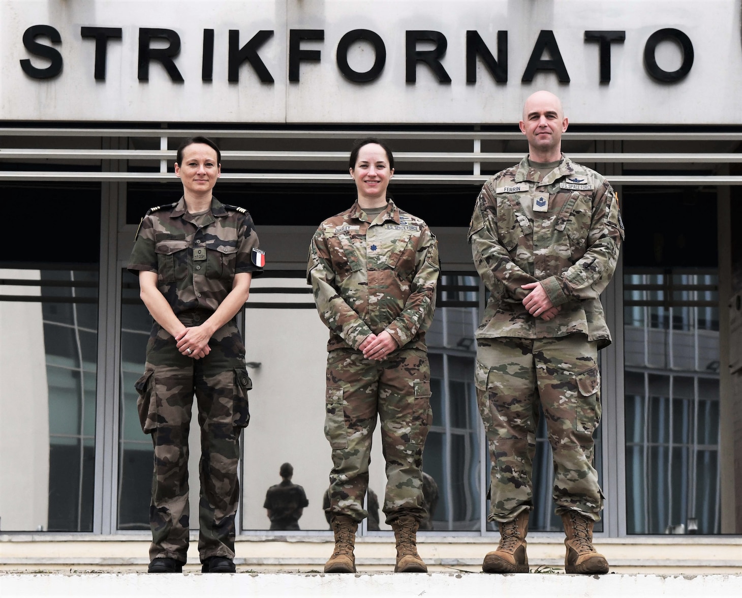 French Air Force Maj. Cécile Stolle and U.S. Space Force Lt. Col. Caitlin Diffley, from the NATO Space Centre in Ramstein, Germany, and Tech. Sgt. Braden Ferrin from U.S. Air Forces in Europe, pose for a photo on Naval Striking and Support Forces NATO base, Portugal, June 14, 2022.