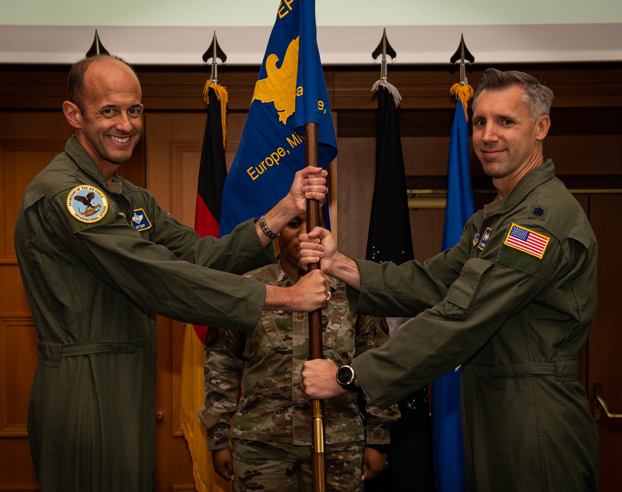 U.S. Air Force Lt. Col. Kevin Thomas, Military Personnel Exchange Program incoming commander, receives command of MPEP from Brig. Gen. John Teichert, assistant deputy under Secretary of the Air Force, International Affairs, during a change of command ceremony.