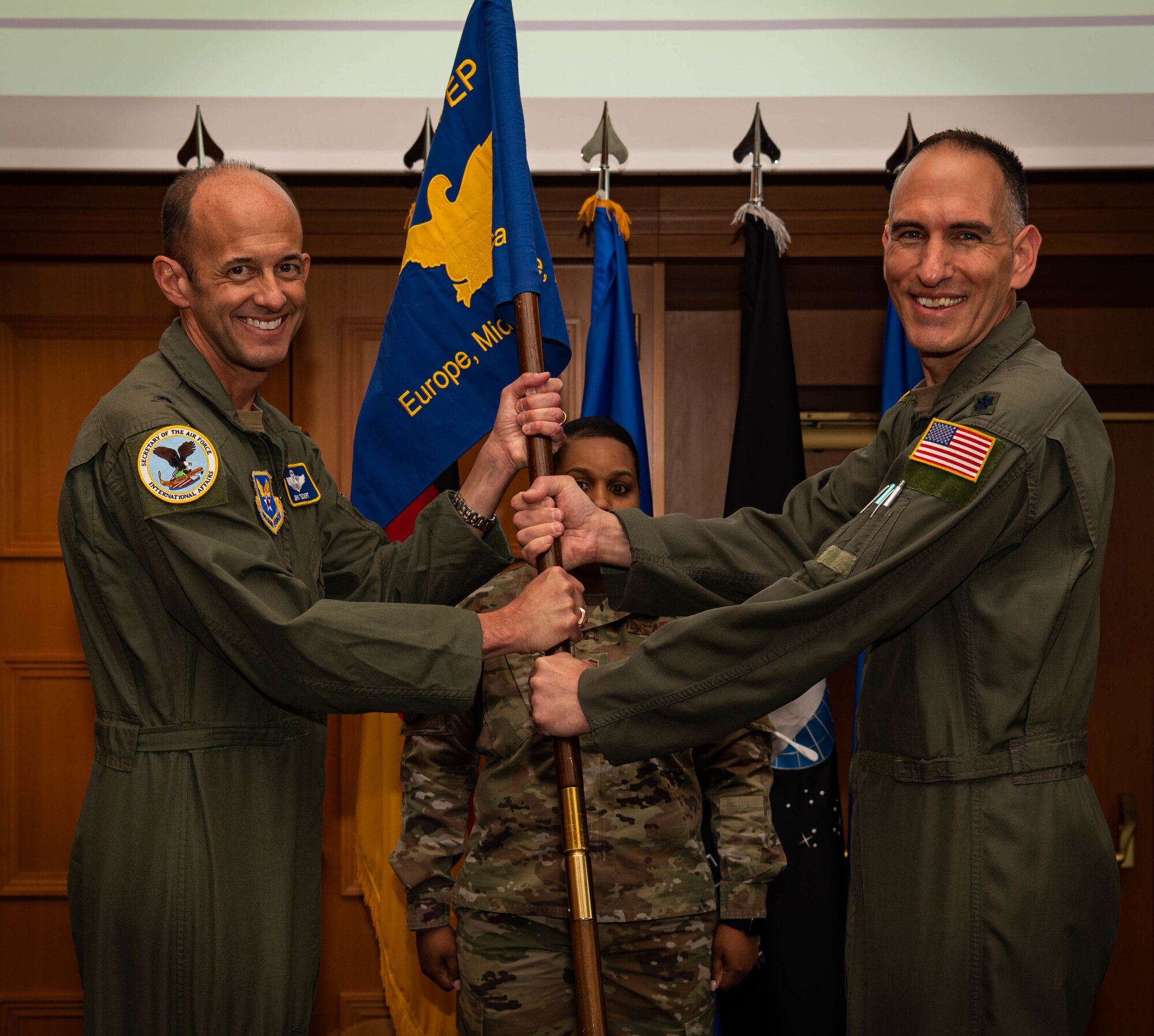 U.S. Air Force Lt. Col. Matthew Polus, Military Personnel Exchange Program outgoing commander, relinquishes command of MPEP to Brig. Gen. John Teichert, assistant deputy under Secretary of the Air Force, International Affairs, during a change of command ceremony.