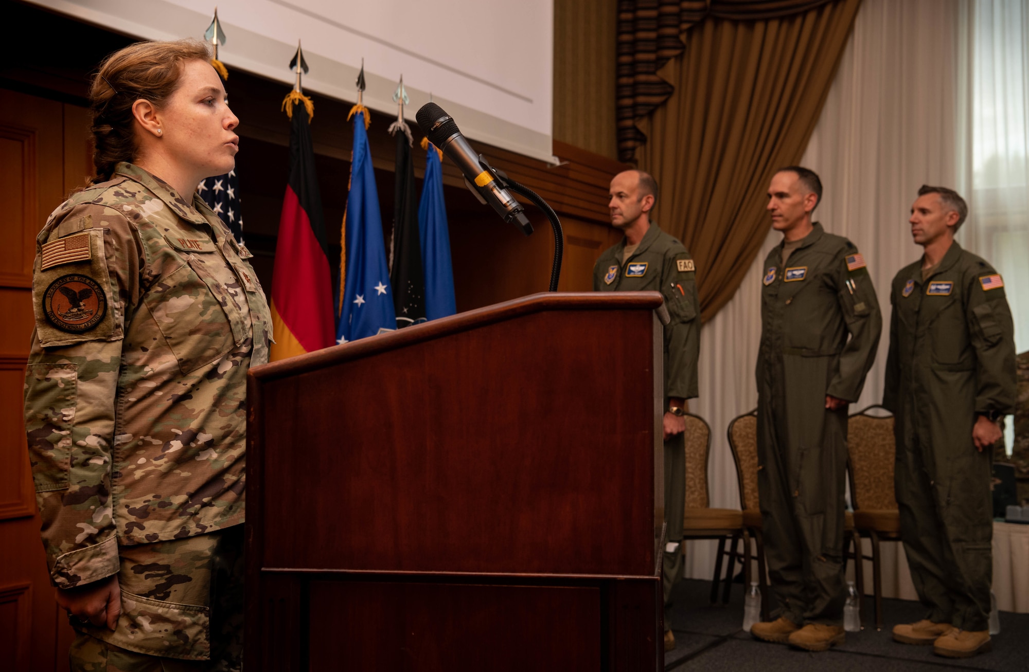 U.S. Air Force Maj. Erin Plate, Military Personnel Exchange Program exchange officer, sings the national anthem during a Military Personnel Exchange Program change of command ceremony.
