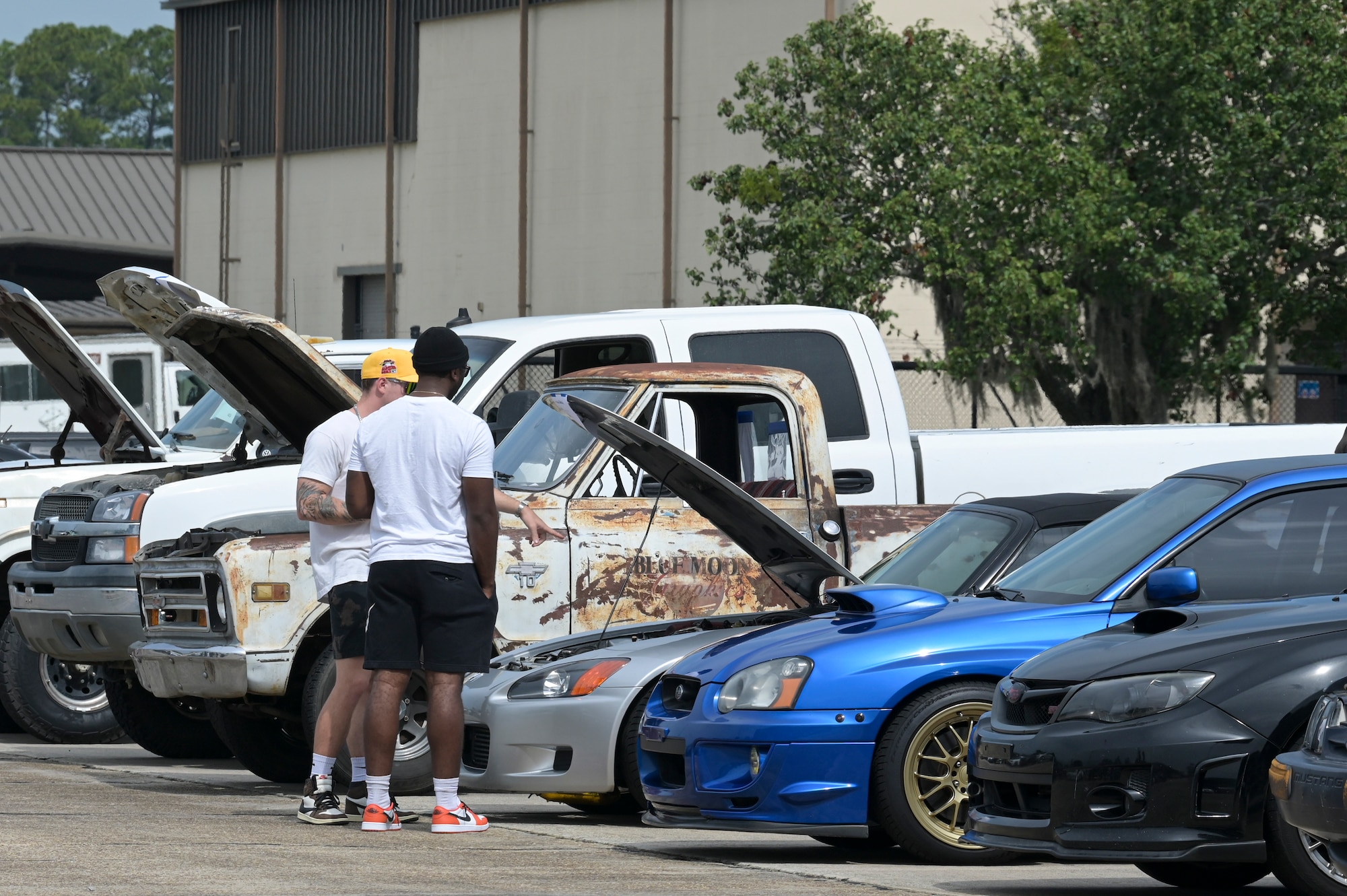 U.S. Air Force Airmen admire a vehicle during a car show at Moody Air Force Base, Georgia, June 11, 2022. Attendees had the opportunity to vote on their favorite vehicle, and a winner was selected among the 88 vehicles on display. (U.S. Air Force photo by Senior Airman Rebeckah Medeiros)
