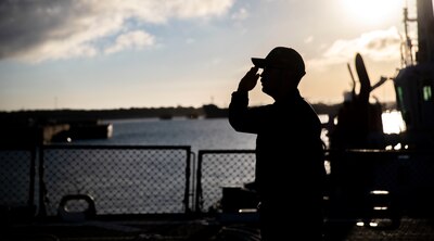Chief Fire Controlman Derek P. Cox salutes the national ensign during morning colors aboard the Arleigh Burke-class guided-missile destroyer USS Arleigh Burke (DDG 51) onboard Naval Station Rota, Spain, June 1, 2022.