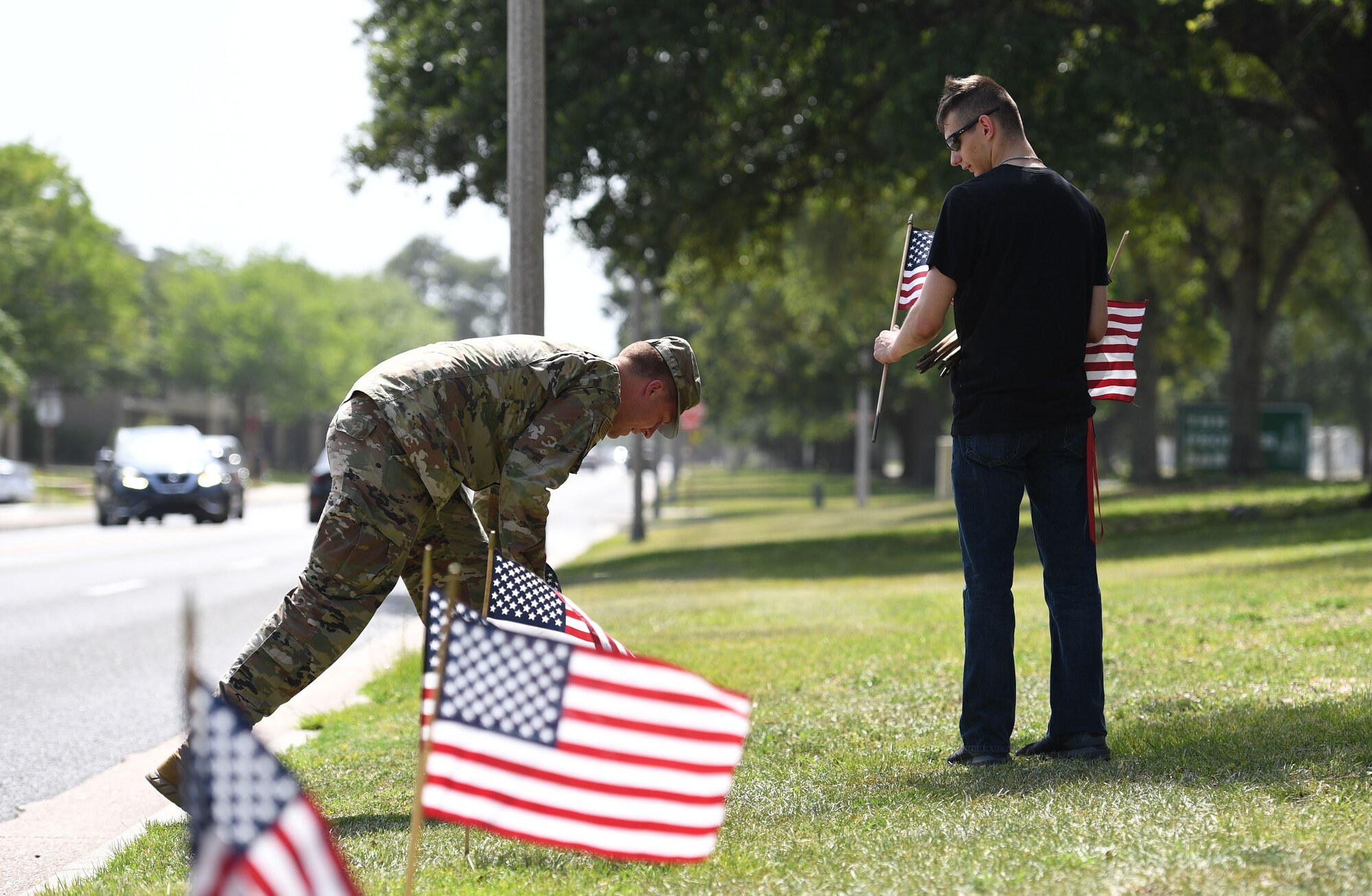 U.S. Air Force Airman 1st Class Shawn Jensen, 81st Diagnostic and Therapeutics Squadron radiology technician, and Airman 1st Class Austin Marino, Keesler Honor Guard member, place U.S. flags in the ground along Meadows Drive at Keesler Air Force Base, Mississippi, June 13, 2022. June 14 is Flag Day, a celebration of the history of the American flag and a time to remember proper etiquette for its display. Flag Day recognizes the adoption of the Stars and Stripes as the official flag of the United States on June 14, 1777, by the Continental Congress meeting in Philadelphia. This is the 5th year that the Air Force Sergeants Association Chapter 652 has volunteered to place 1,000 flags along Larcher Blvd. and Meadows Drive. (U.S. Air Force photo by Kemberly Groue)