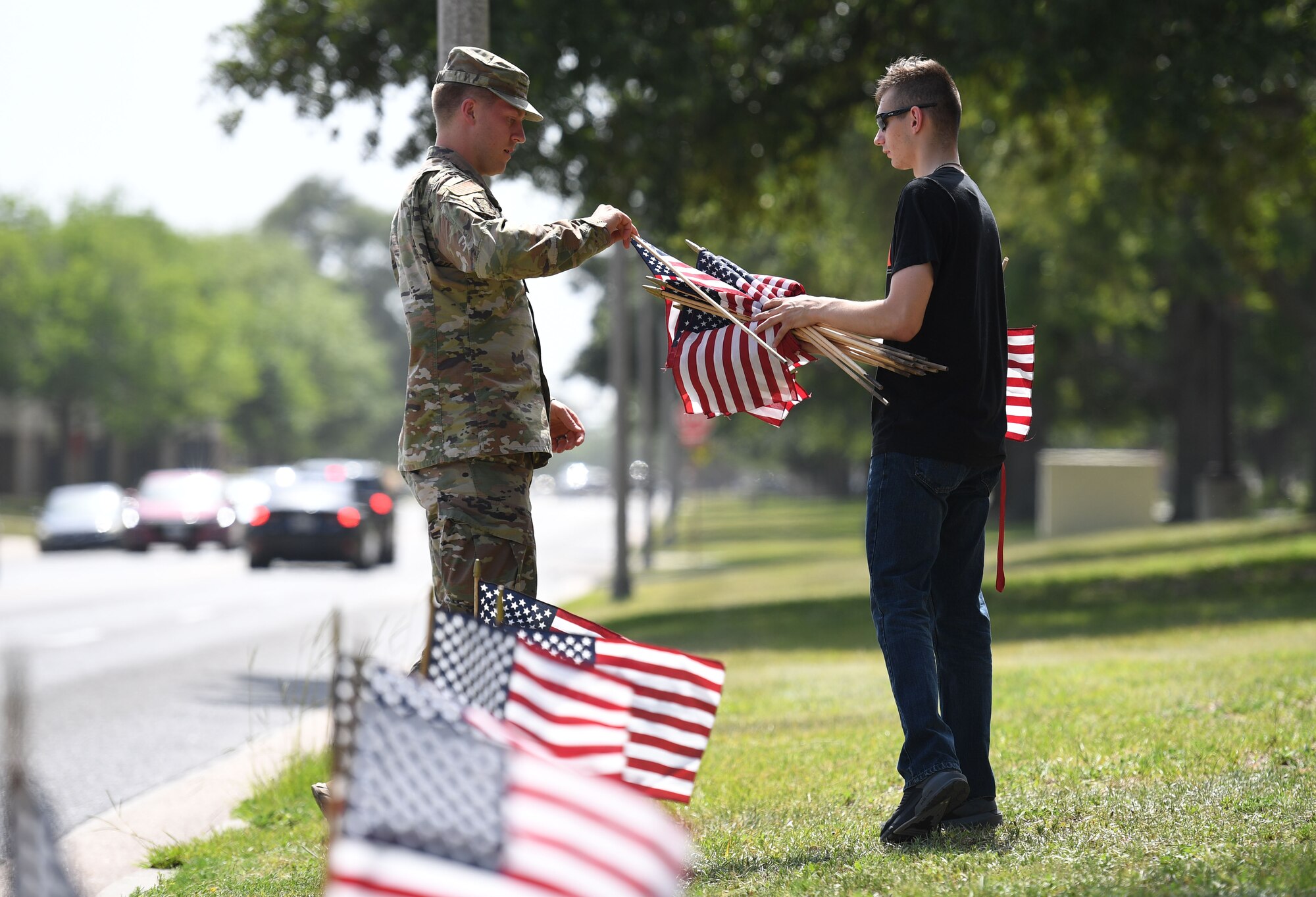 U.S. Air Force Airman 1st Class Shawn Jensen, 81st Diagnostic and Therapeutics Squadron radiology technician, and Airman 1st Class Austin Marino, Keesler Honor Guard member, place U.S. flags in the ground along Meadows Drive at Keesler Air Force Base, Mississippi, June 13, 2022. June 14 is Flag Day, a celebration of the history of the American flag and a time to remember proper etiquette for its display. Flag Day recognizes the adoption of the Stars and Stripes as the official flag of the United States on June 14, 1777, by the Continental Congress meeting in Philadelphia. This is the 5th year that the Air Force Sergeants Association Chapter 652 has volunteered to place 1,000 flags along Larcher Blvd. and Meadows Drive. (U.S. Air Force photo by Kemberly Groue)