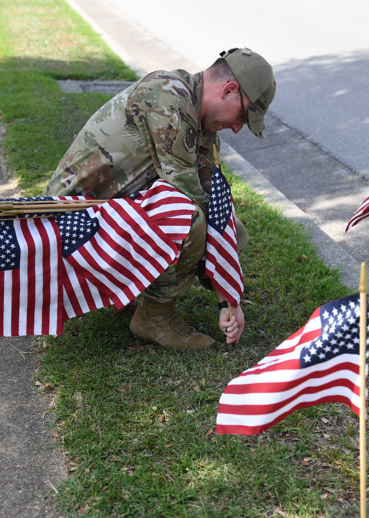 U.S. Air Force Airman 1st Class Thomas Lenoir, 81st Training Wing paralegal, places U.S. flags in the ground along Larcher Blvd. at Keesler Air Force Base, Mississippi, June 13, 2022. June 14 is Flag Day, a celebration of the history of the American flag and a time to remember proper etiquette for its display. Flag Day recognizes the adoption of the Stars and Stripes as the official flag of the United States on June 14, 1777, by the Continental Congress meeting in Philadelphia. This is the 5th year that the Air Force Sergeants Association Chapter 652 has volunteered to place 1,000 flags along Larcher Blvd. and Meadows Drive. (U.S. Air Force photo by Kemberly Groue)