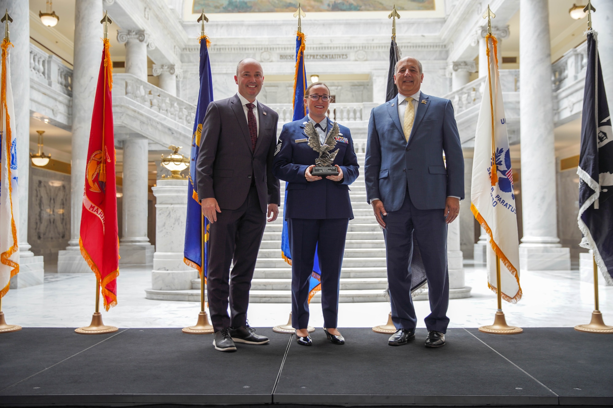 Master Sgt. Sierra Beers, reservist in the 67th Aerial Port Squadron, poses with Utah Gov. Spencer Cox and Utah Department of Military & Veteran Affairs Gary Harter