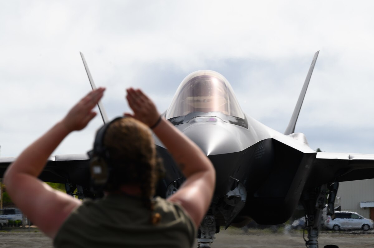 U.S. Air Force Staff Sgt. Megan Symons, a 354th Air Expeditionary Wing crew chief, marshalls an F-35A Lightning II assigned to the 356th Expeditionary Fighter Squadron, 354th AEW, upon initial arrival at Palau International Airport in support of Valiant Shield 22, June 11, 2022. VS22 is the ninth iteration of the series that began in 2006. It is a field training exercise that aims to prepare the Joint Force to rapidly respond to crises and contingencies across the spectrum of operations from humanitarian assistance and disaster relief to armed conflict. (U.S. Air Force photo by Senior Airman Jose Miguel T. Tamondong)