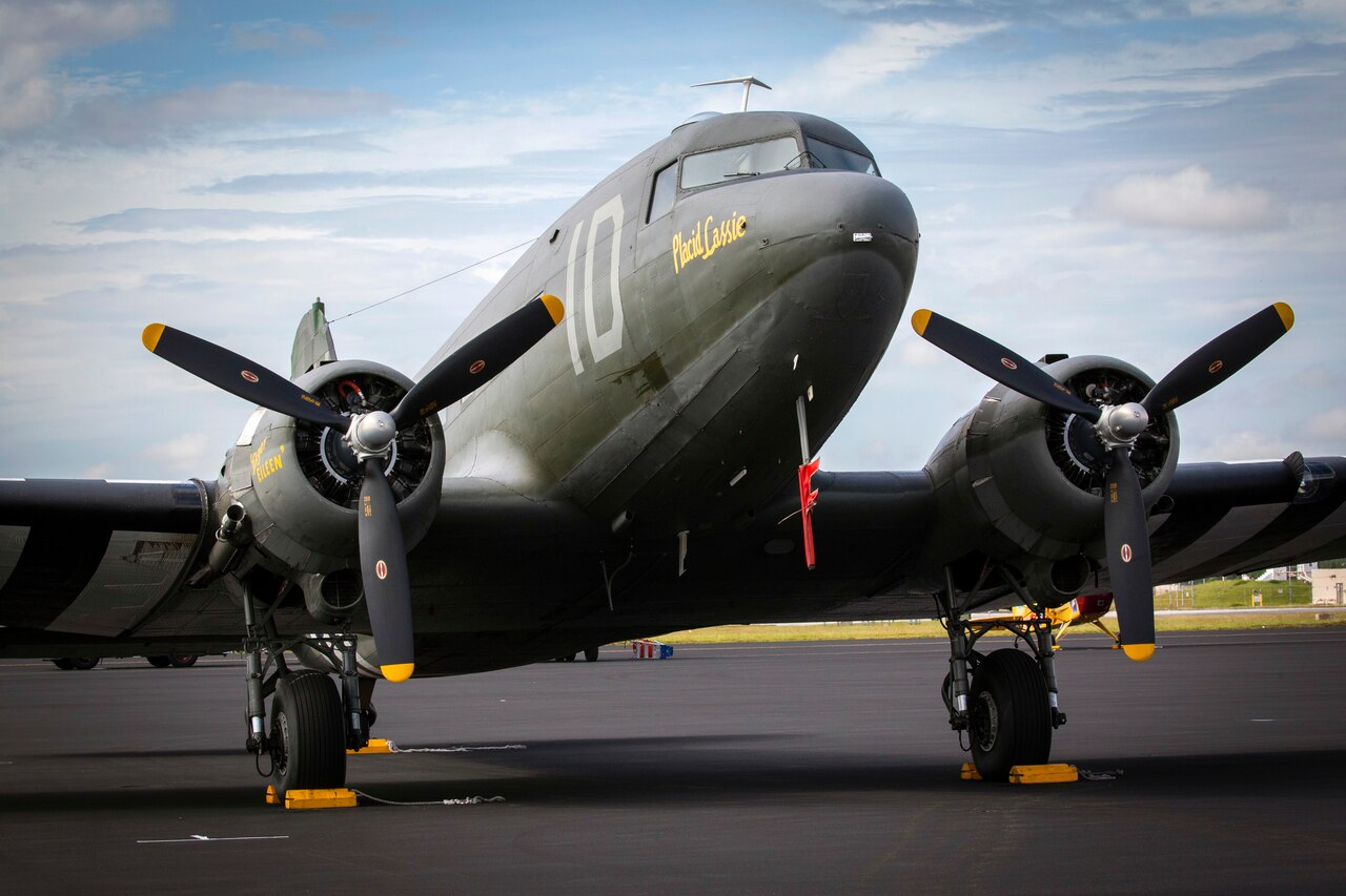 A World War II-era propeller airplane sits on tarmac.