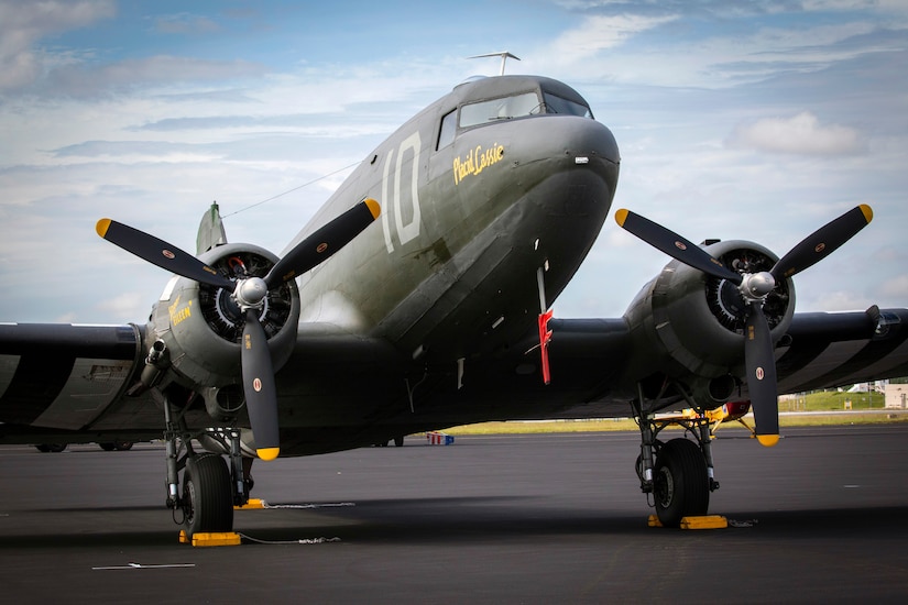 A World War II-era propeller airplane sits on tarmac.