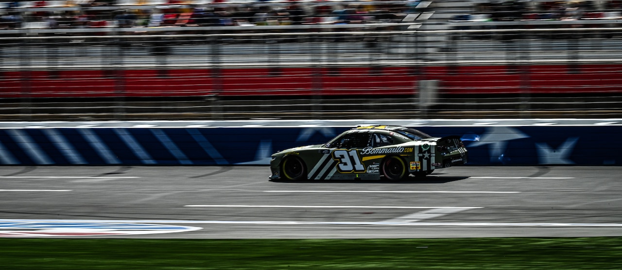 A racecar moves on a racetrack.