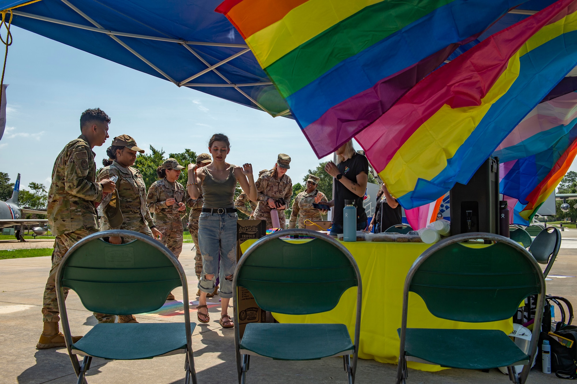 people standing under a tent with Pride flags